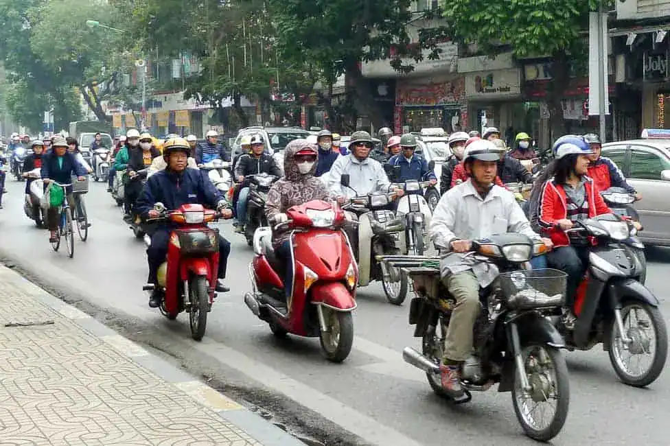 Trafic de motos et scooters dans une rue animée au Vietnam.