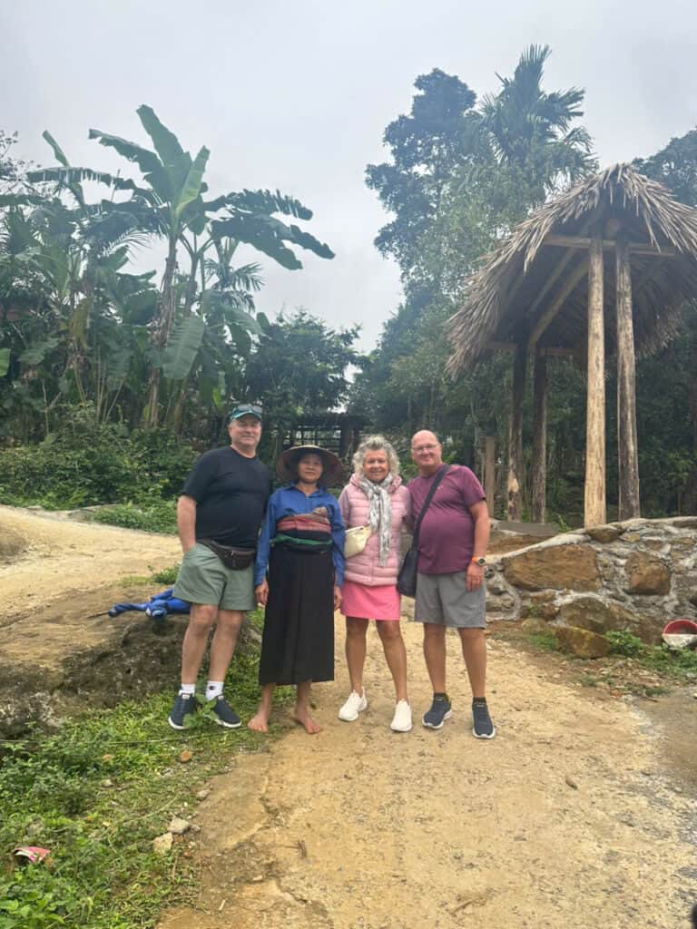 Groupe de touristes devant une cabane en bambou dans la jungle vietnamienne.