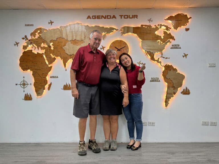 Groupe de voyageurs devant une carte du monde en voyage Vietnam.