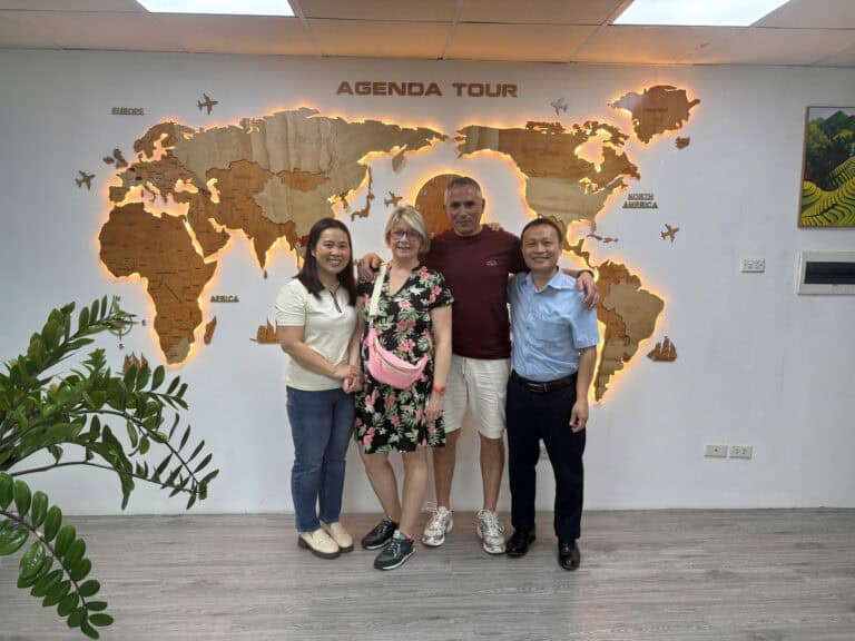 Photo de groupe devant la carte du monde chez Agenda Tour Vietnam.