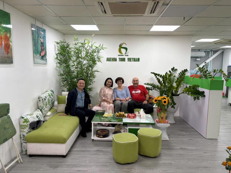 Photo d'équipe dans le bureau d'Agence Tour Vietnam, avec un décor vert et accueillant.