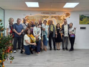 Groupe de touristes devant le mur d'accueil d'Agenda Tour Vietnam, avec une carte du monde en arrièr.