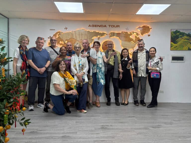 Photo de groupe d'explorateurs devant la carte du Vietnam à l'agence.