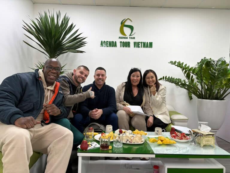 Photo de groupe avec touristes souriants à l'agence Agenda Tour Vietnam.