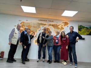 Photo d'une équipe d'agents de voyage devant une carte du monde.